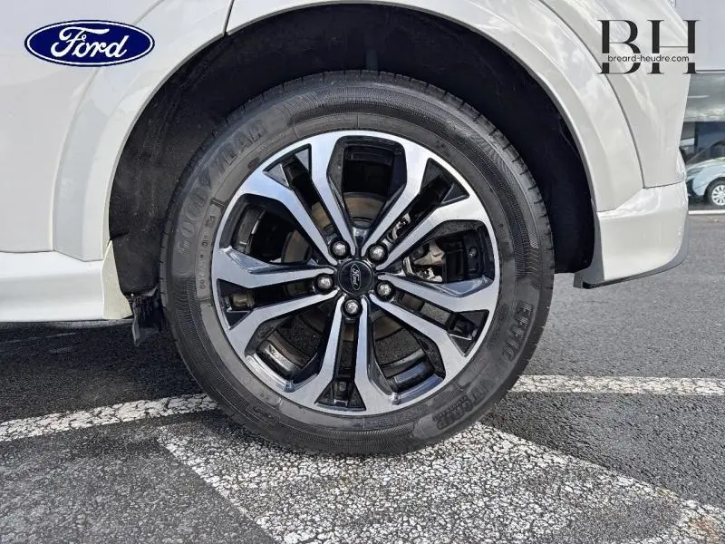 Gros plan sur la roue avant droite en jante alu noir et argent du Ford Puma blanc Premium Metropolis.