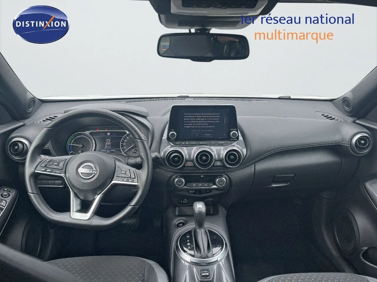 Intérieur noir du Nissan Juke 2024, vue frontale du tableau de bord avec écran tactile et volant multifonction.