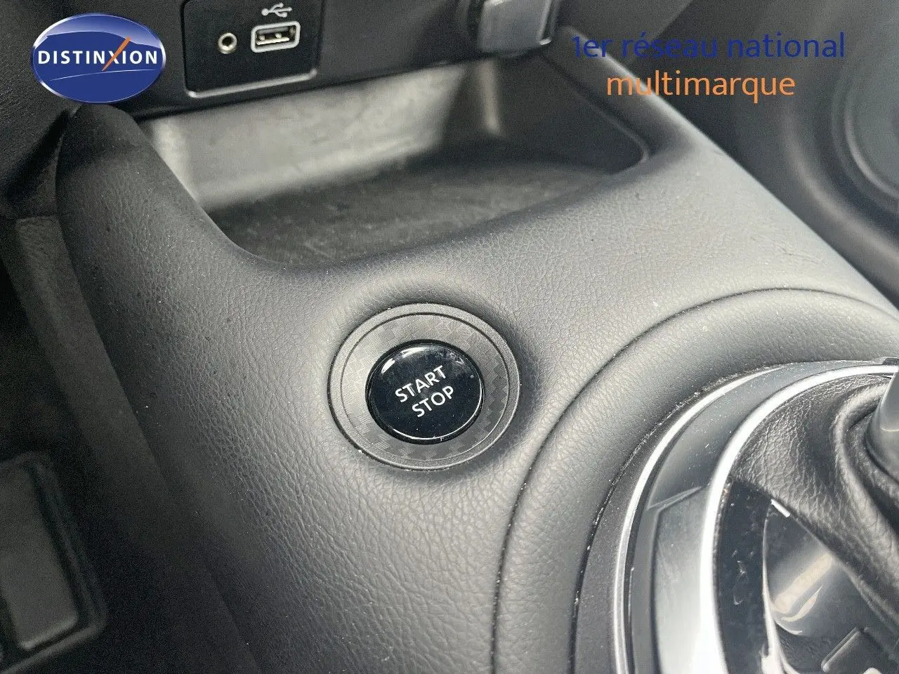 Gros plan sur le bouton start/stop et la console centrale en cuir noir du Nissan Juke blanc nacré 2024.