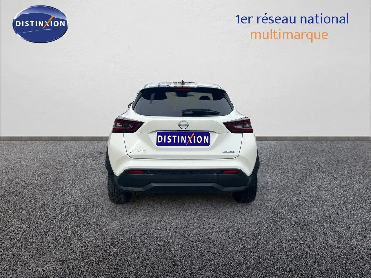 Vue arrière d'un Nissan Juke blanc nacré 2024 avec feux LED et logo Nissan bien visibles.