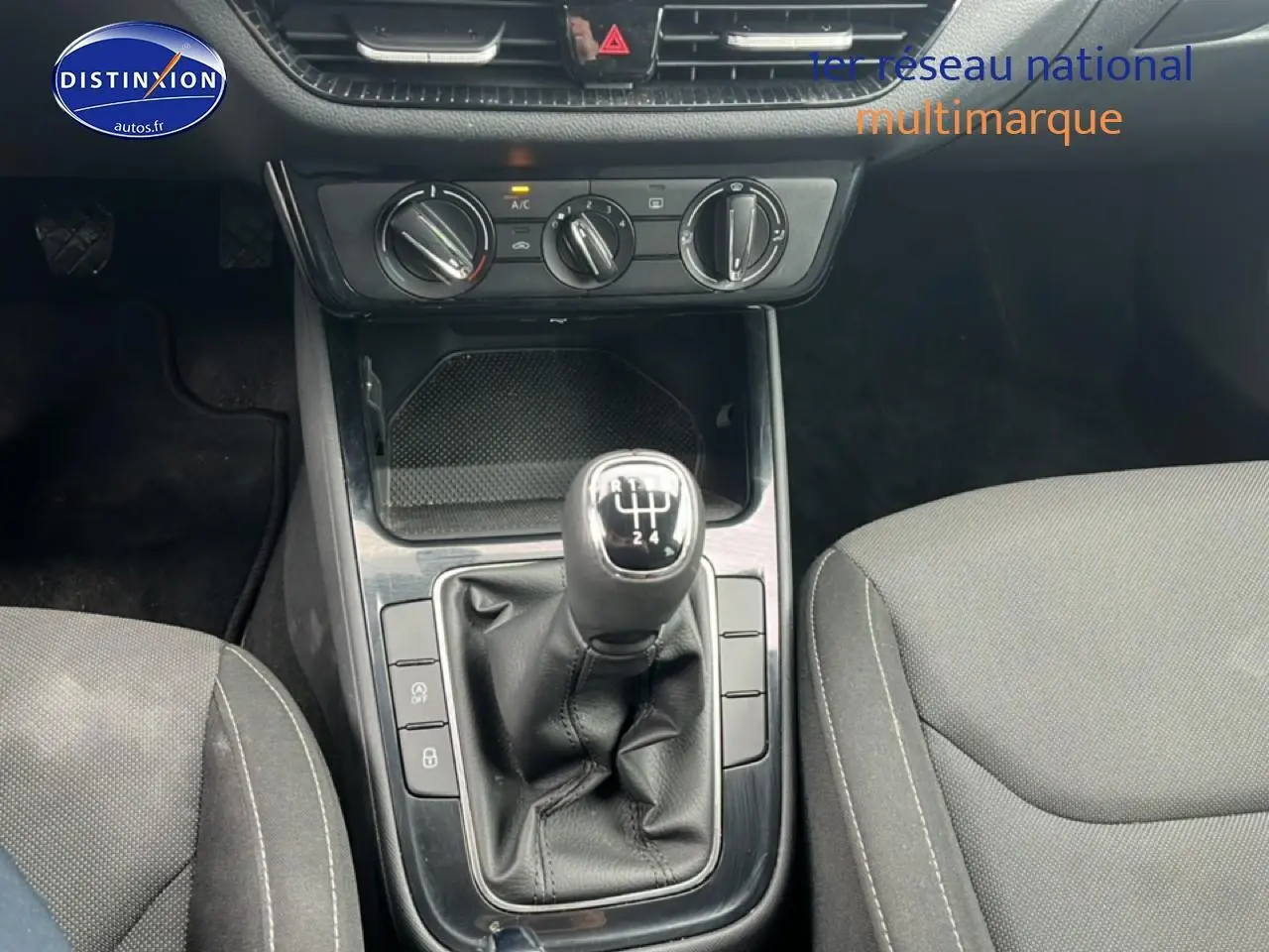 Gros plan sur la console centrale de la Skoda Fabia blanche 2025 avec levier de vitesse manuel et commandes de climatisation.
