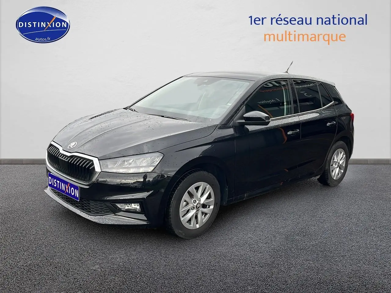 Vue 3/4 avant droite d'une Skoda Fabia noire 2025 avec jantes alu et feux LED, stationnée sur sol gris.