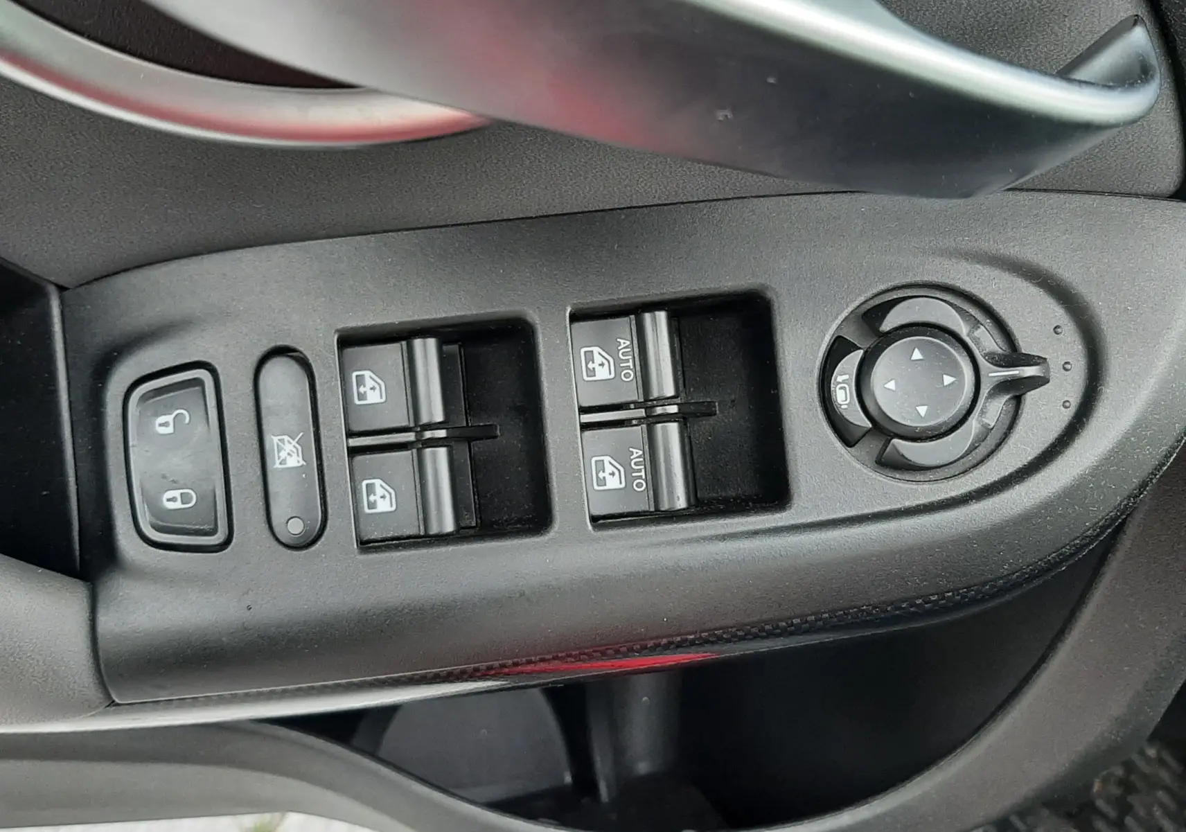 Gros plan sur la commande des vitres et rétroviseurs côté conducteur d'une FIAT 500X rouge de 2016.