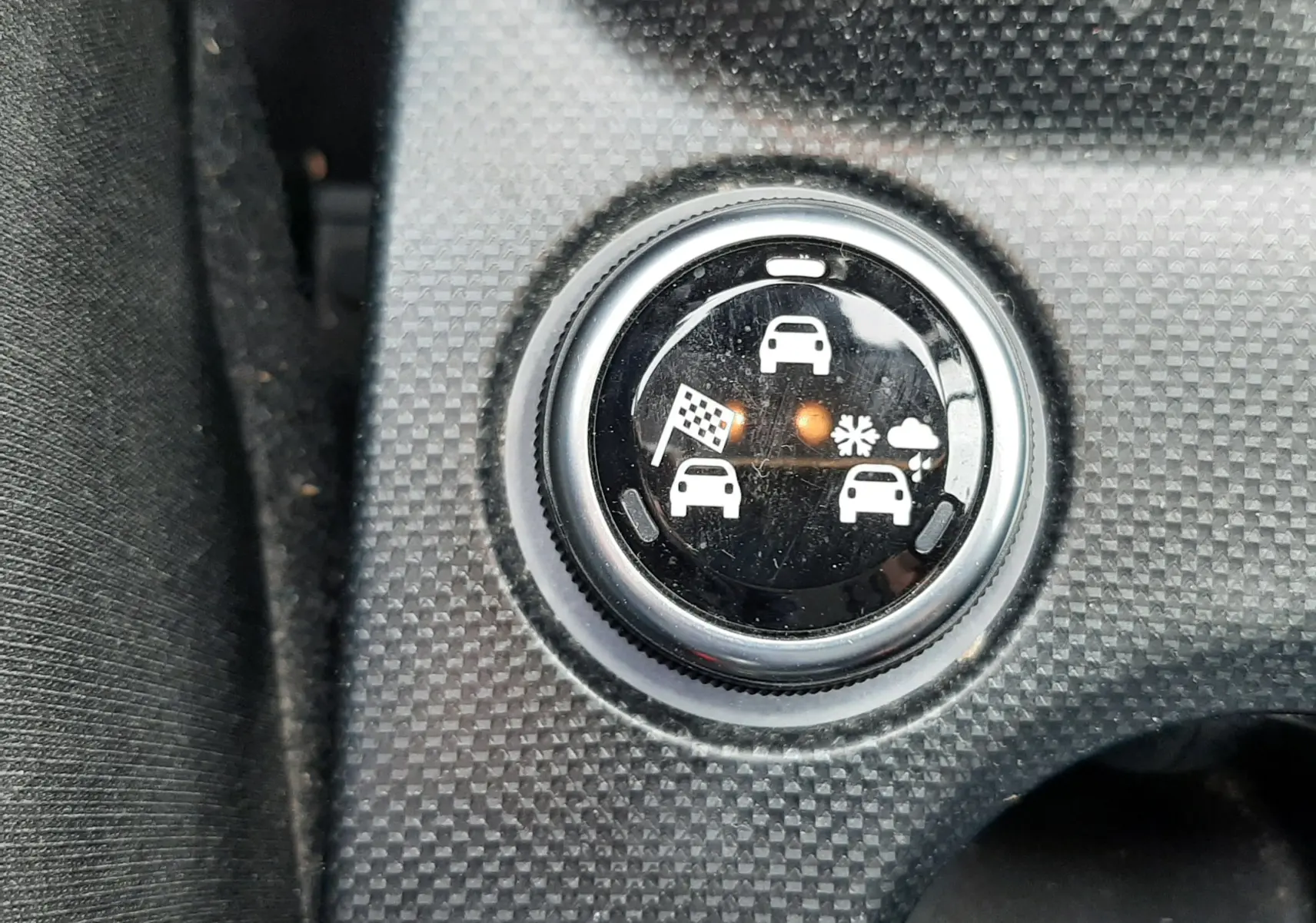 Gros plan sur le sélecteur de mode de conduite du Fiat 500X rouge, montrant les icônes de terrain et météo.