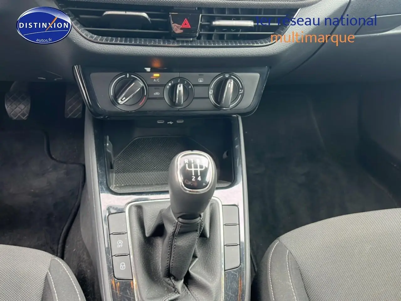Vue rapprochée de la console centrale intérieure de la Skoda Fabia blanche 2025 avec levier de vitesse manuel et commandes de climatisation.