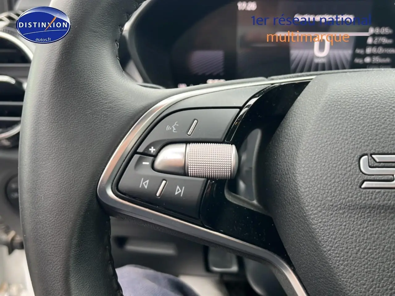 Gros plan sur les commandes gauche du volant cuir multifonction de la Skoda Fabia blanche 2025.