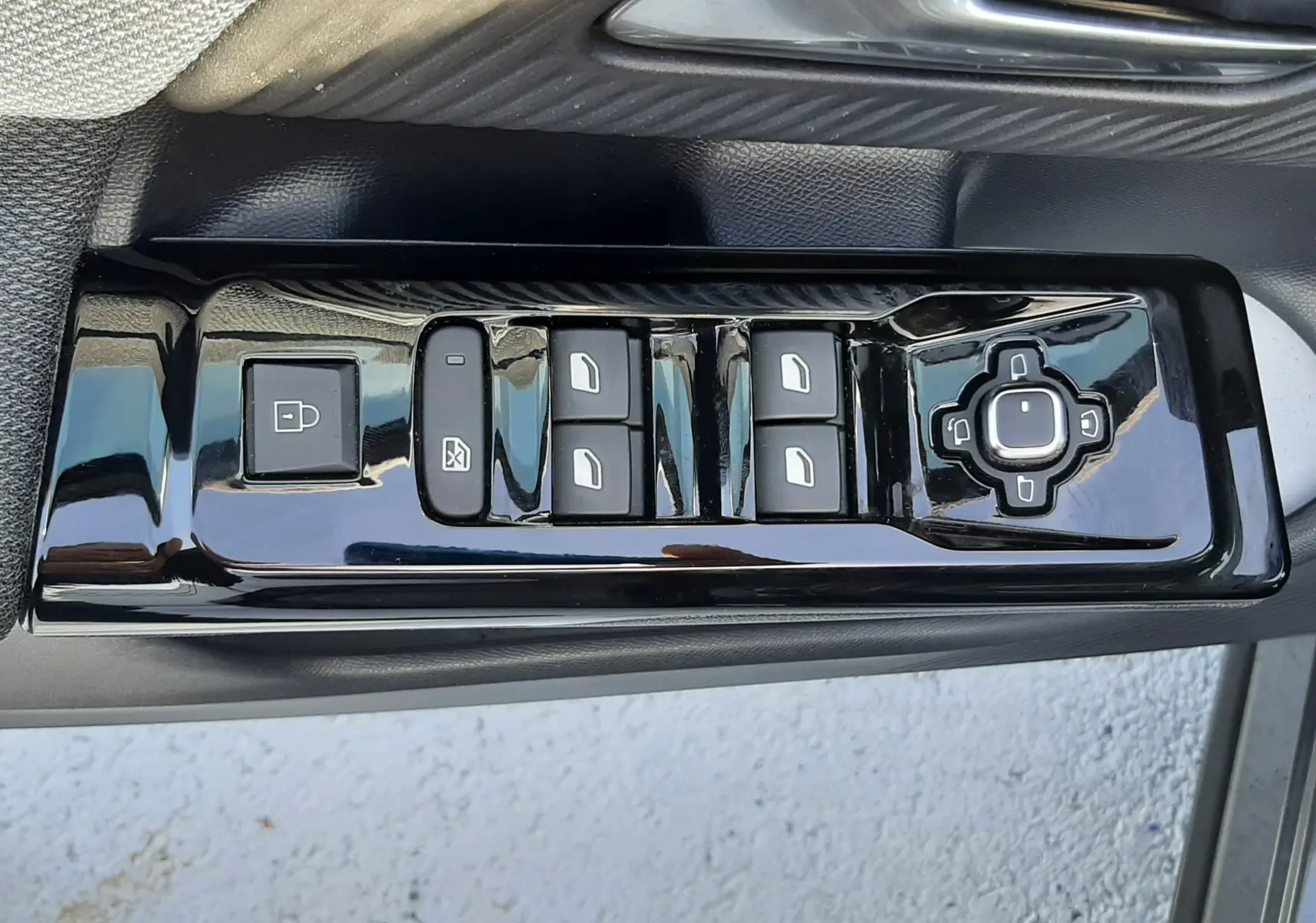 Gros plan sur la commande des vitres et rétroviseurs côté gauche d’un Citroën C5 Aircross gris platinium 2026.