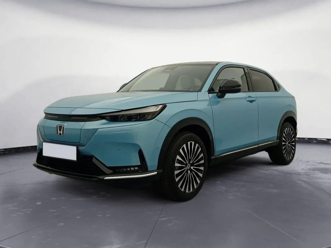 Honda e:Ny1 204 ch Advance bleu électrique, vue 3/4 avant droit mettant en valeur ses jantes stylisées et son design moderne.
