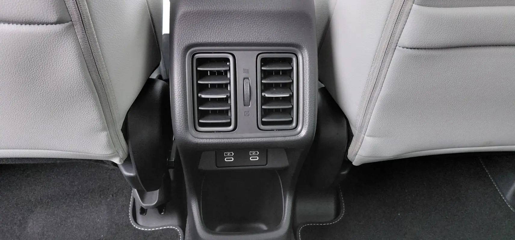 Détail de la console arrière avec bouches d’aération et deux ports USB dans une Honda e:Ny1 Advance 2025.