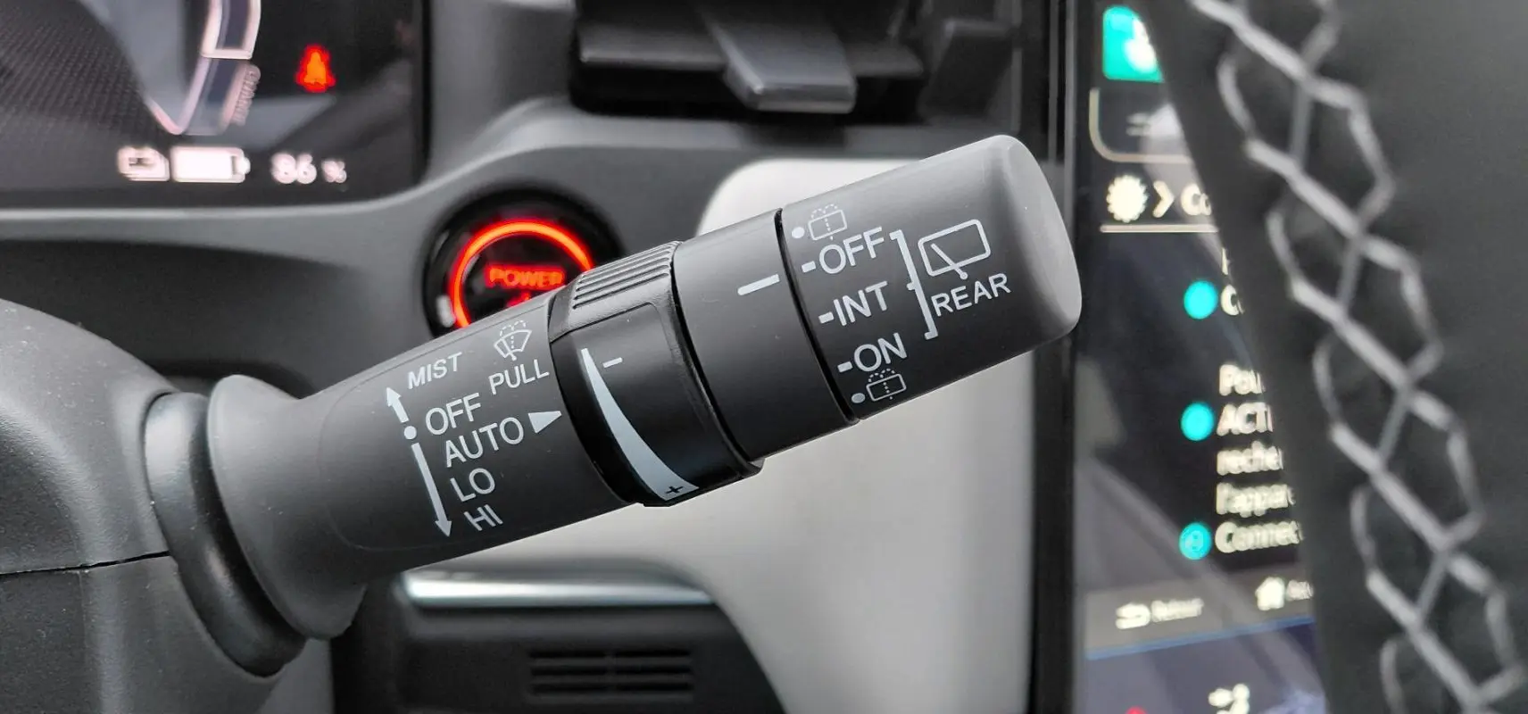 Gros plan sur la commande des essuie-glaces du Honda e:Ny1 204 ch Advance 2025, intérieur avec bouton Power rouge.