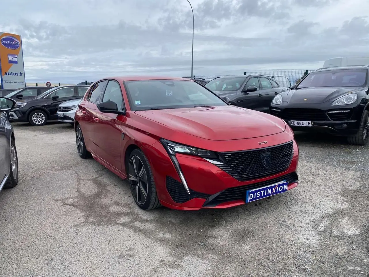 Peugeot 308 GT rouge Elixir vue 3/4 avant droit, avec calandre noire et phares LED distinctifs.