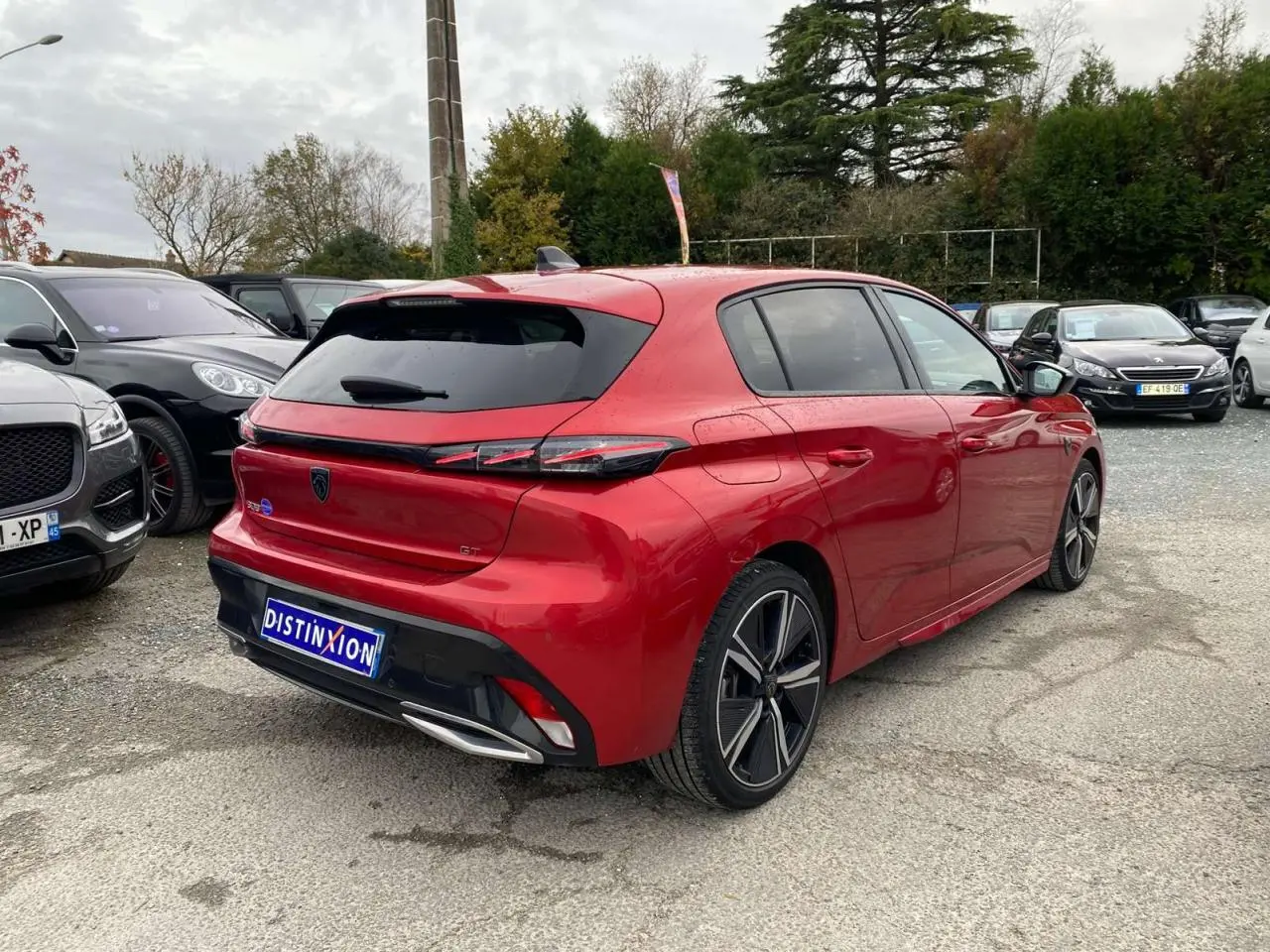 Peugeot 308 GT rouge Elixir vue 3/4 arrière droit, avec feux arrière LED et jantes alliage distinctives.