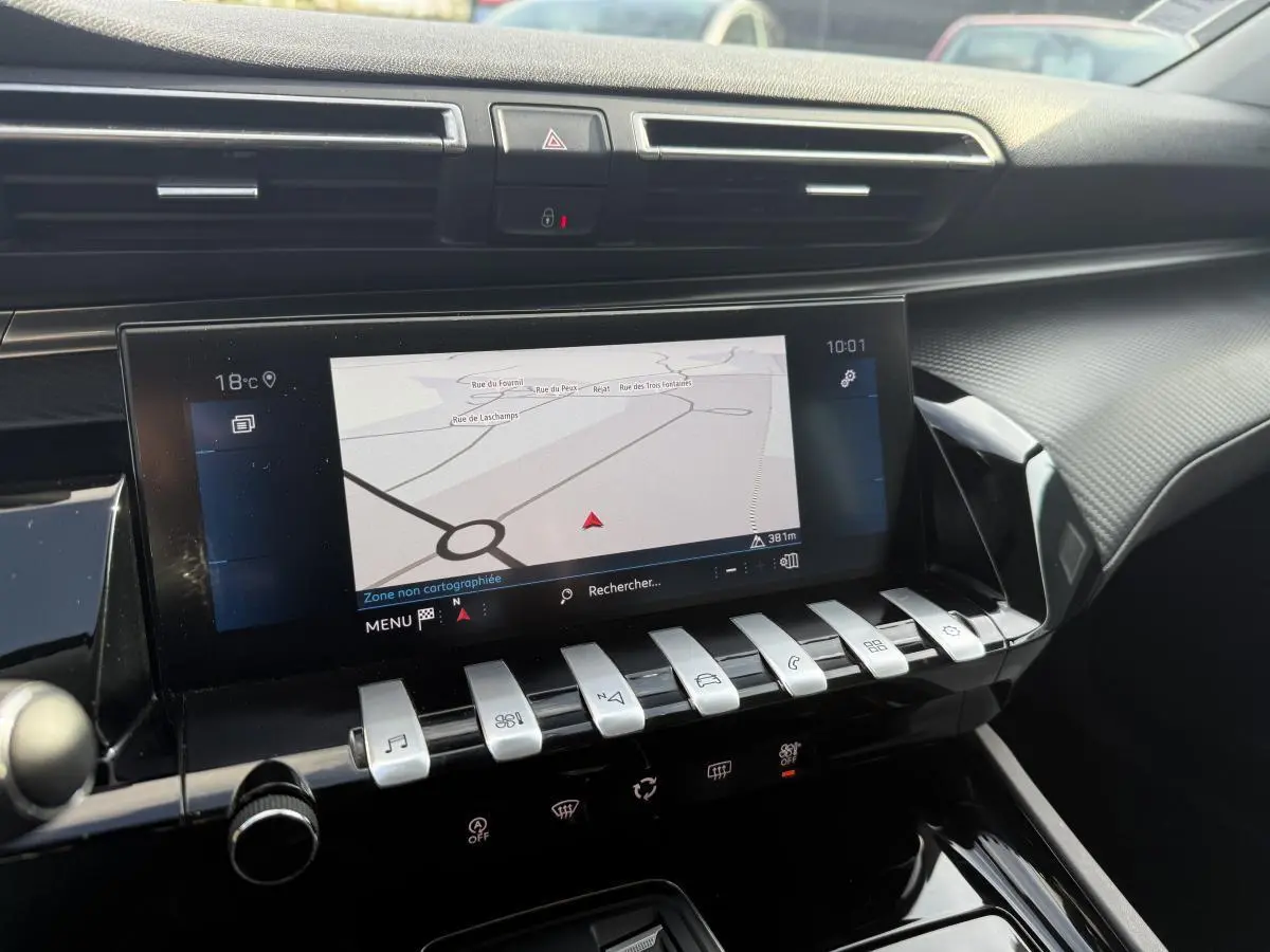 Vue rapprochée de la console centrale de la Peugeot 508 2019, écran tactile avec navigation et commandes piano chromées.