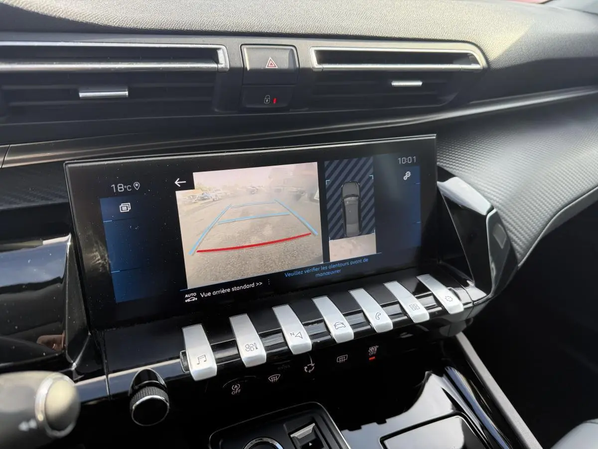 Vue rapprochée de l’écran tactile central affichant la caméra 360° dans l’habitacle noir du Peugeot 508 bleu.