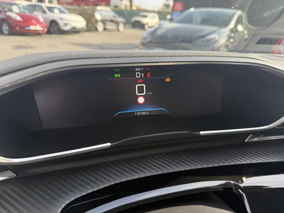 Tableau de bord numérique de Peugeot 508 bleu, vue frontale avec décor carbone et affichage digital.