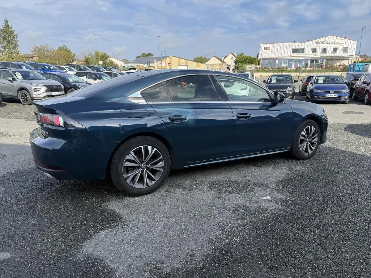 Peugeot 508 bleu métallisé vue de profil côté droit, avec jantes alliage et vitres surteintées.