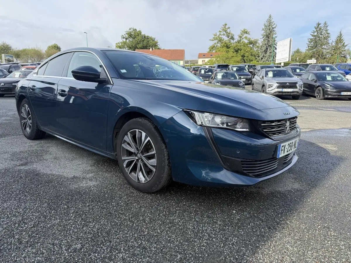 Peugeot 508 bleu métallisé vue 3/4 avant droit avec calandre noire et jantes alliage 17 pouces.
