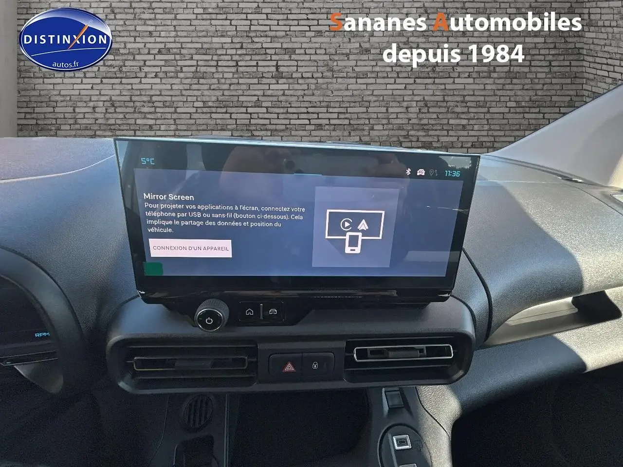 Vue intérieure du tableau de bord du Citroën Berlingo blanc 2025 avec écran tactile central et commandes de climatisation.