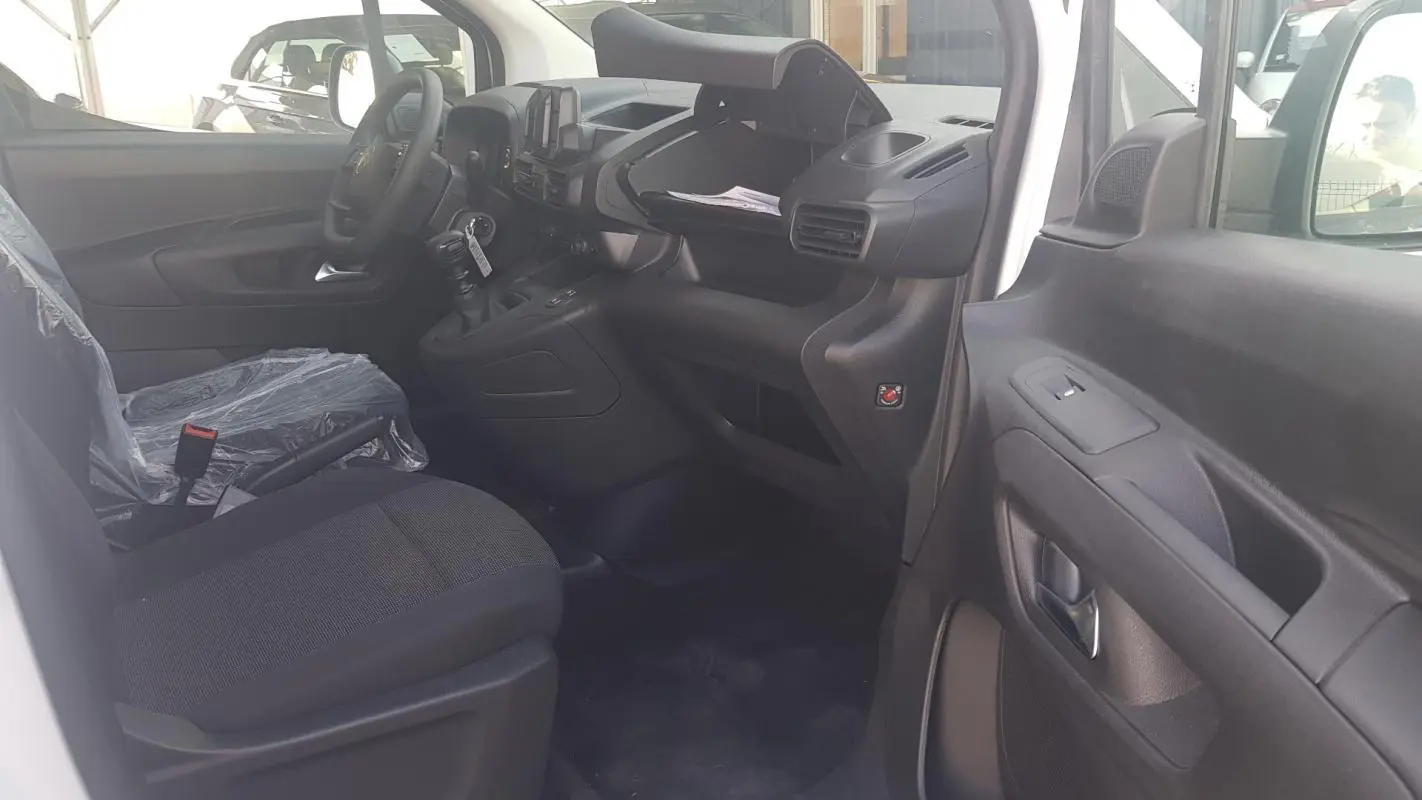 Intérieur côté conducteur du Citroën Berlingo blanc 2025, vue sur tableau de bord et siège avant avec volant multifonctions.