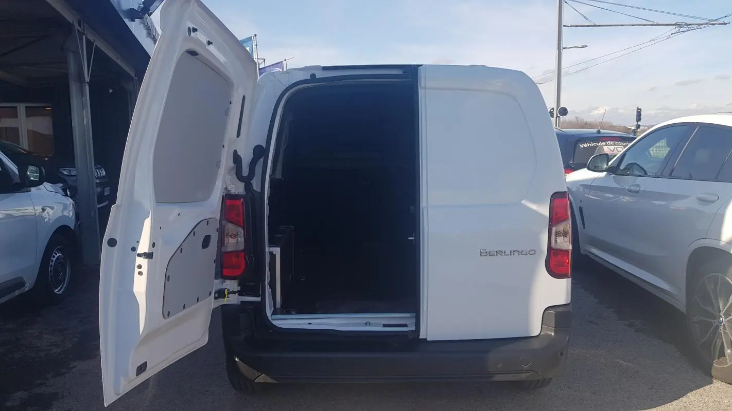 Vue arrière d’un Citroën Berlingo blanc 2025 avec porte latérale ouverte montrant l’espace de chargement vide.