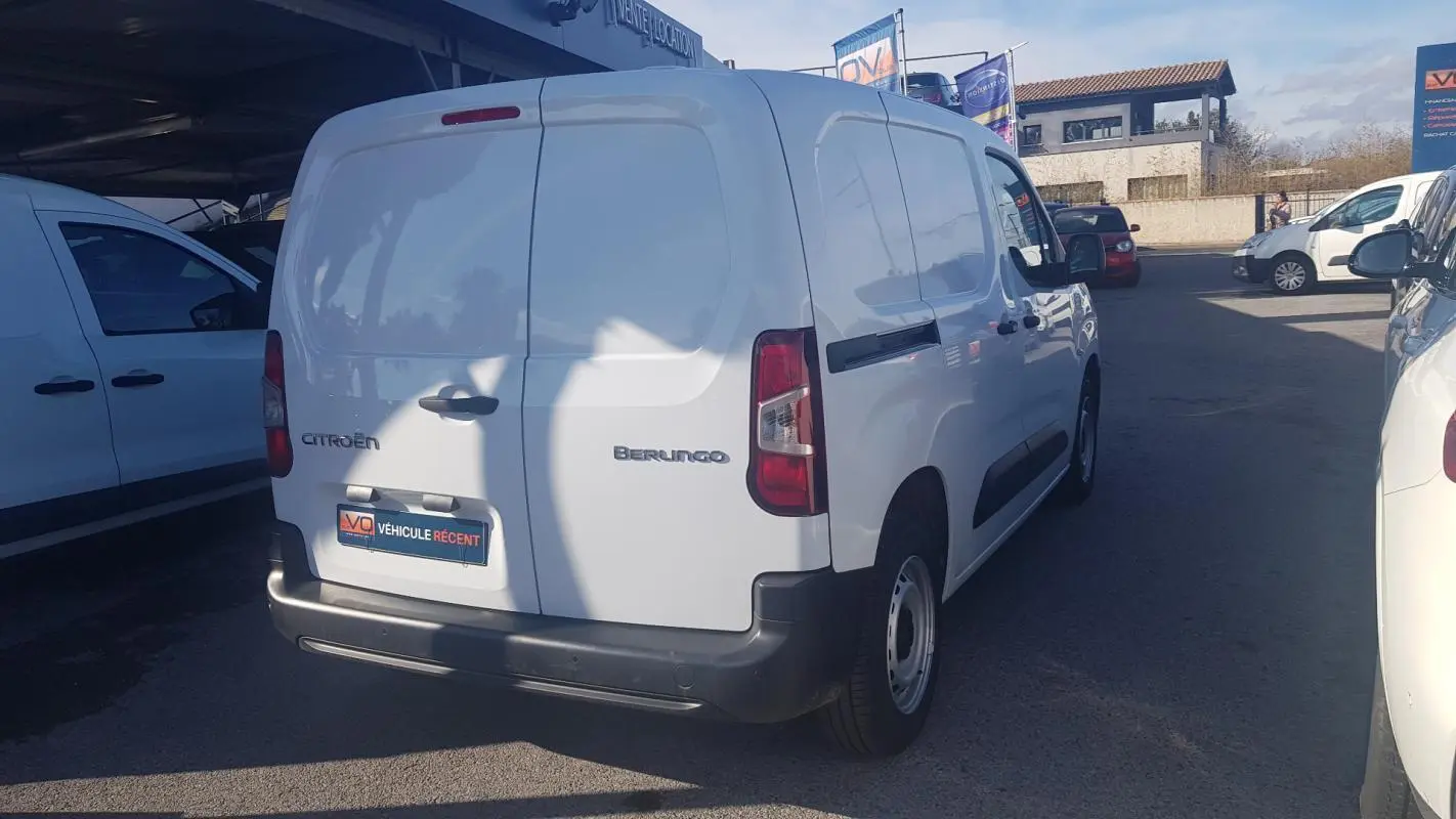 Vue 3/4 arrière droite d’un Citroën Berlingo blanc utilitaire avec porte latérale et jantes acier 15 pouces.