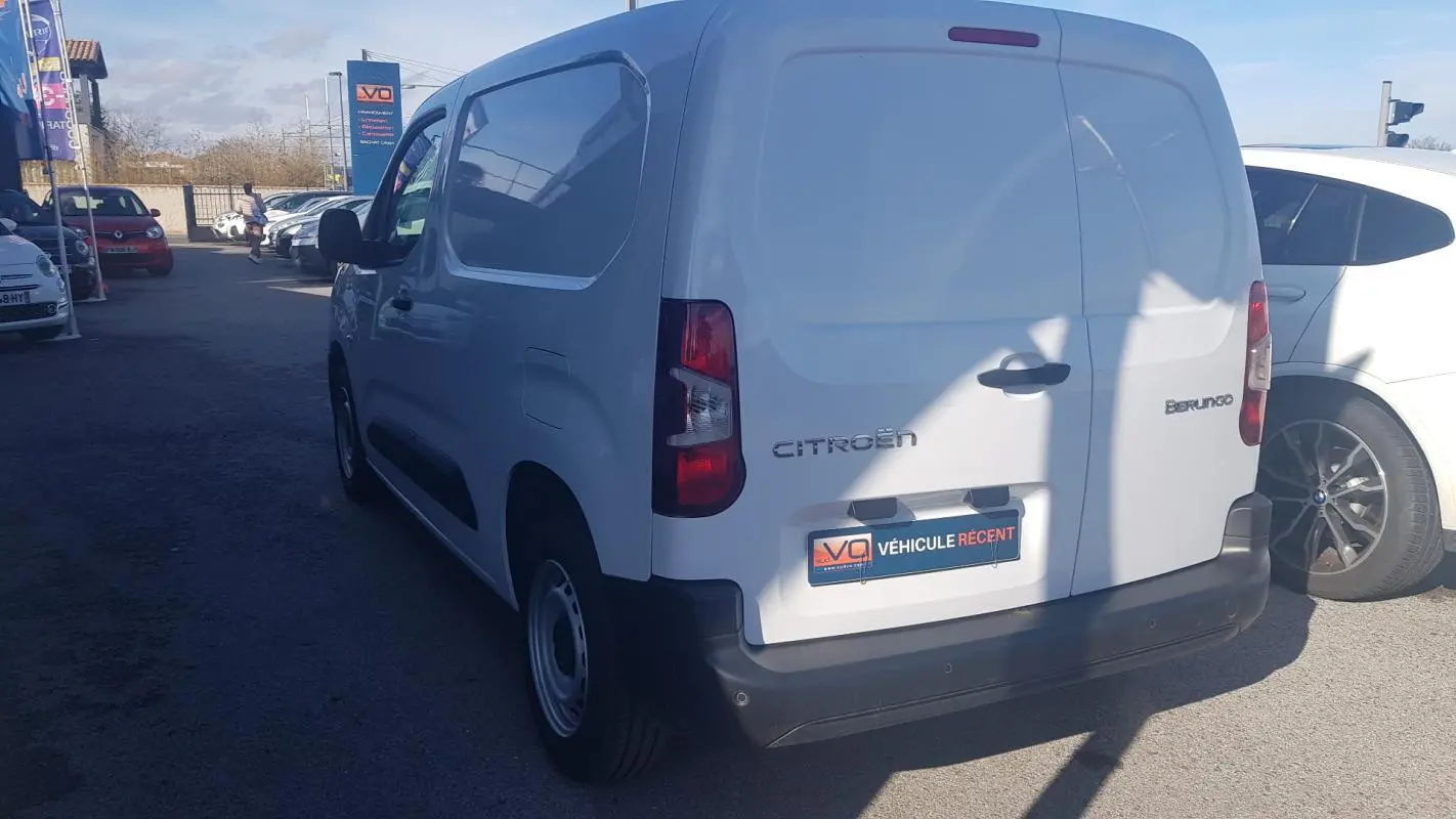 Vue 3/4 arrière droite d’un Citroën Berlingo blanc utilitaire avec porte latérale et jantes acier 15 pouces.