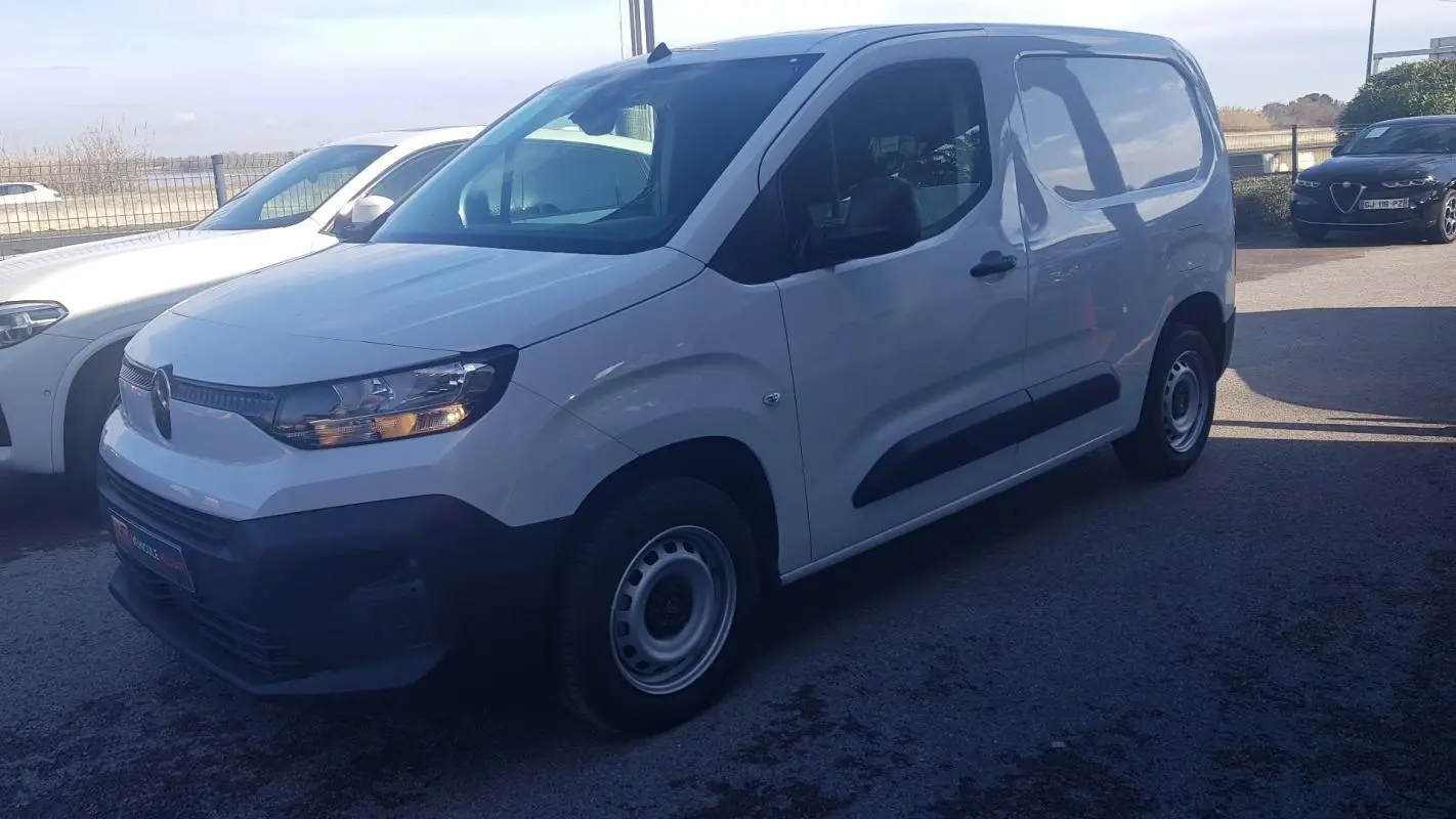 Vue 3/4 avant droit d’un Citroën Berlingo blanc 2025 avec porte latérale et jantes acier 15 pouces.