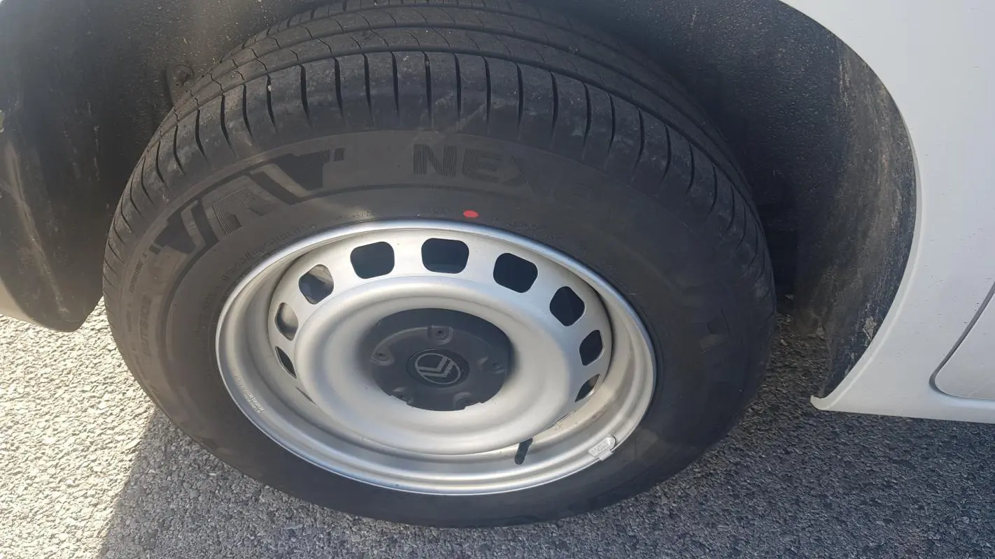 Gros plan sur la roue avant gauche du Citroën Berlingo blanc 2025 avec jante acier 15 pouces et pneu Nexen.