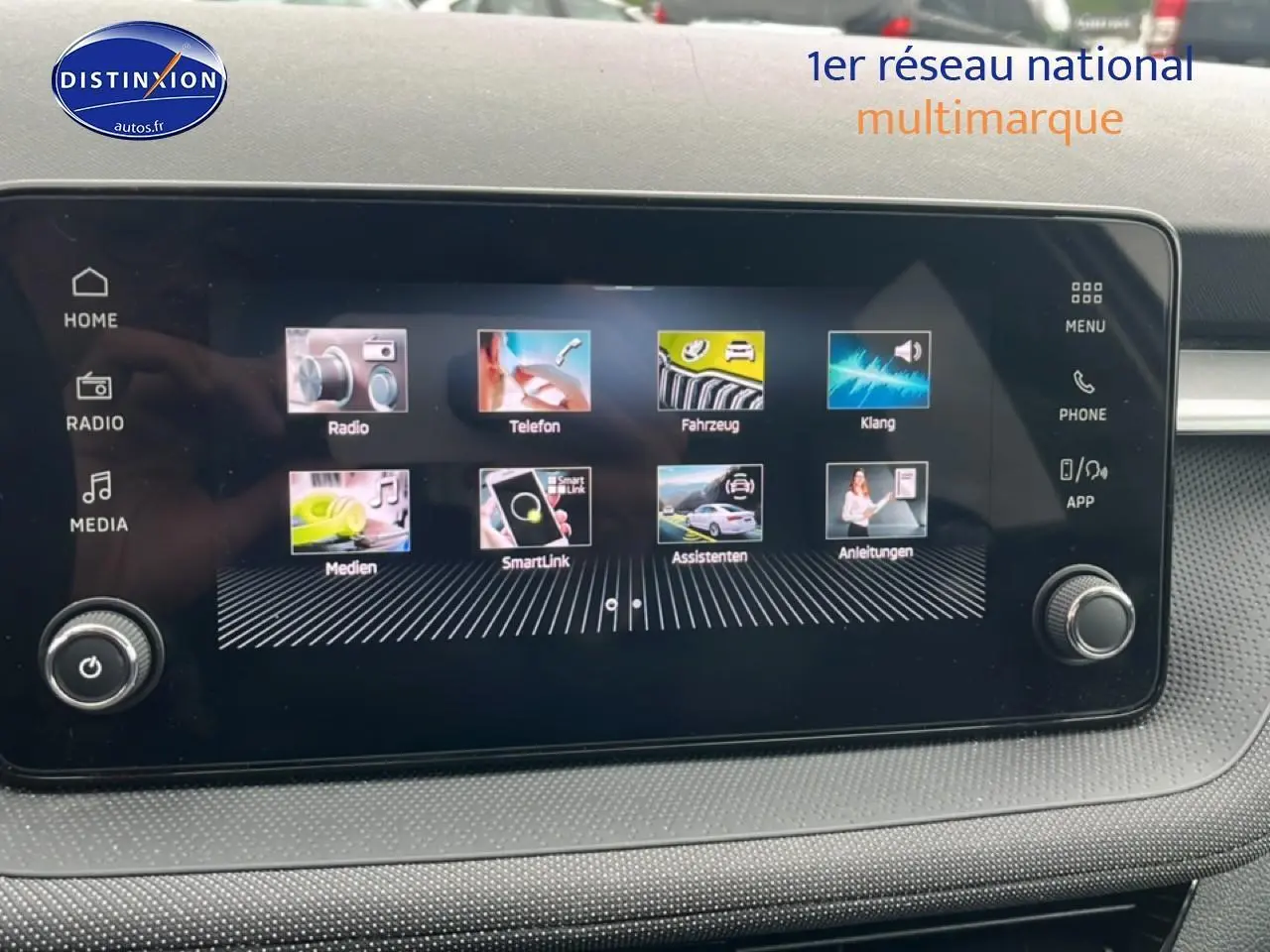 Écran tactile central affichant le menu multimédia du Skoda Fabia blanc, vue intérieure frontale.