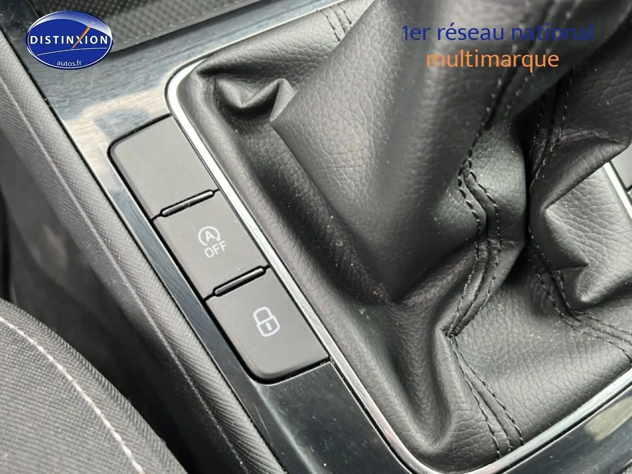 Gros plan sur la console centrale noire de la Skoda Fabia blanche, avec levier de vitesse manuel et boutons de commande.