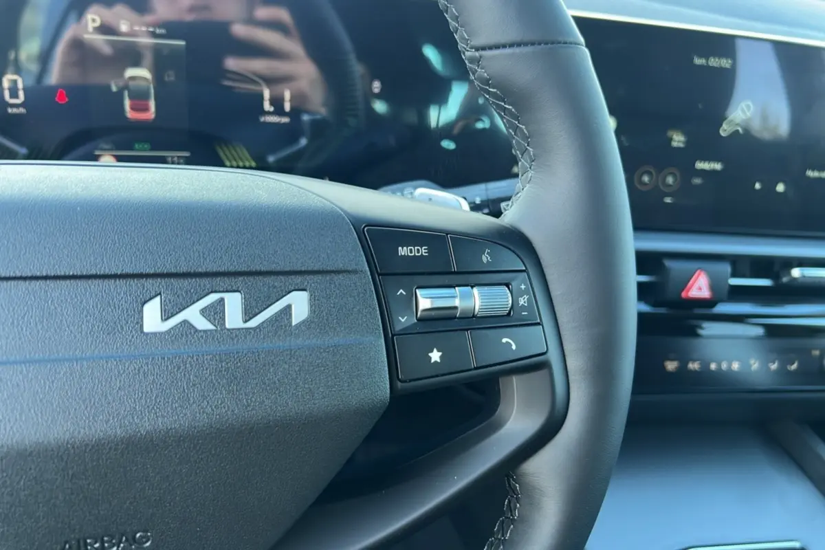 Gros plan sur le volant cuir multifonctions du Kia Sportage 2026, avec logo KIA et commandes intégrées.
