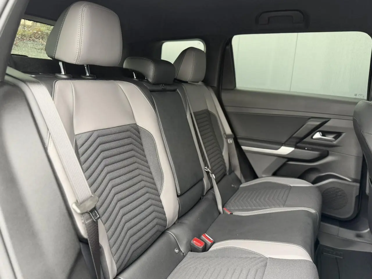 Vue intérieure côté droit des sièges arrière en cuir gris clair et tissu noir du Jeep Compass Hybrid 2026.