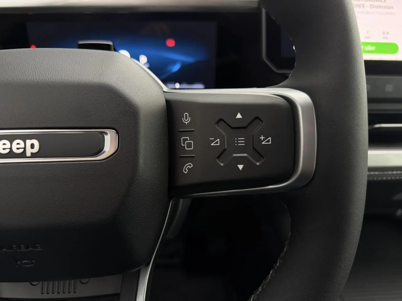 Gros plan sur la partie droite du volant noir du Jeep Compass 2026 avec commandes multifonctions et logo Jeep visible.
