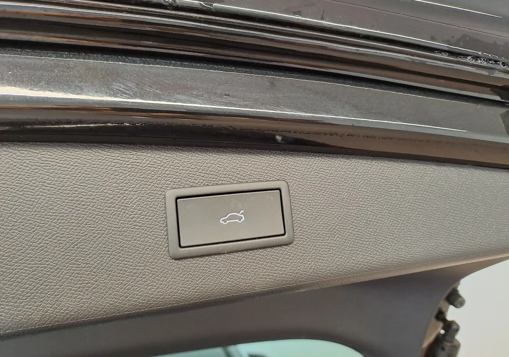 Bouton d'ouverture électrique du coffre sur la partie intérieure du hayon d'une CUPRA LEON ST Noir Minuit.