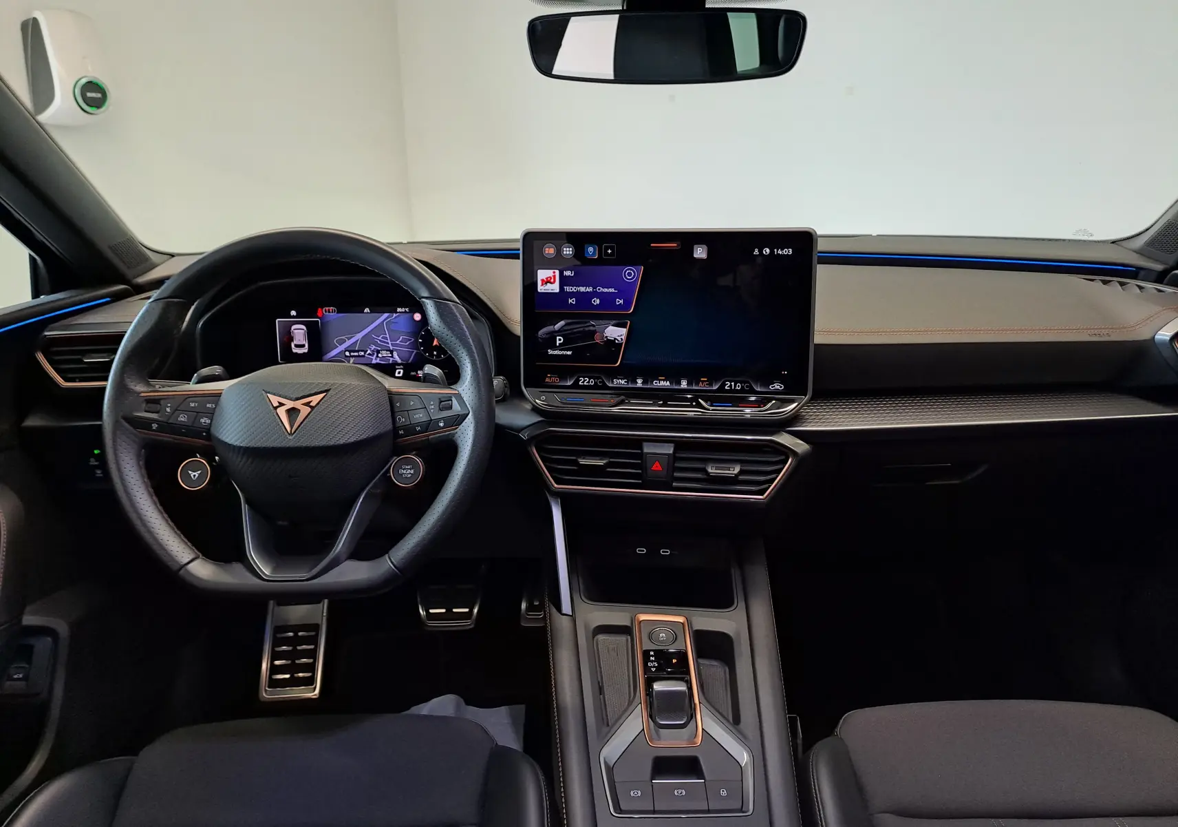 Vue intérieure du tableau de bord de la CUPRA LEON ST 2025 avec écran tactile central et volant multifonction noir.