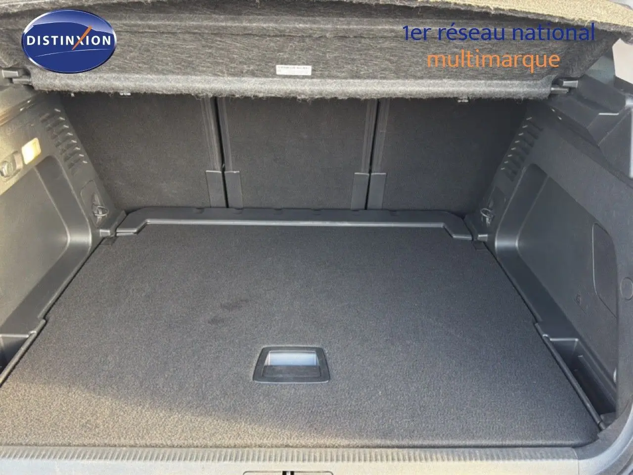 Coffre ouvert vu de l'arrière d'un Citroën C5 Aircross gris Artense Metal, avec plancher plat et habillage noir.