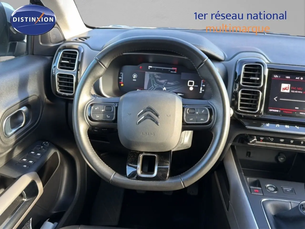 Vue intérieure centrée sur le volant cuir noir et le tableau de bord numérique du Citroën C5 Aircross 2021 gris Artense.