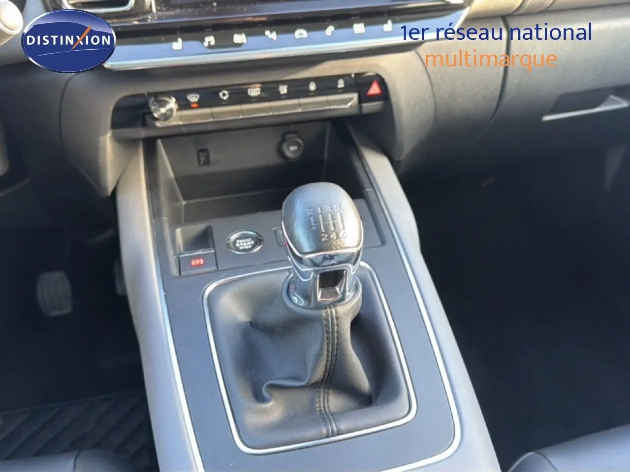 Gros plan sur la commande de la boîte manuelle noire dans l’habitacle sombre d’une Citroën C5 Aircross gris Artense.