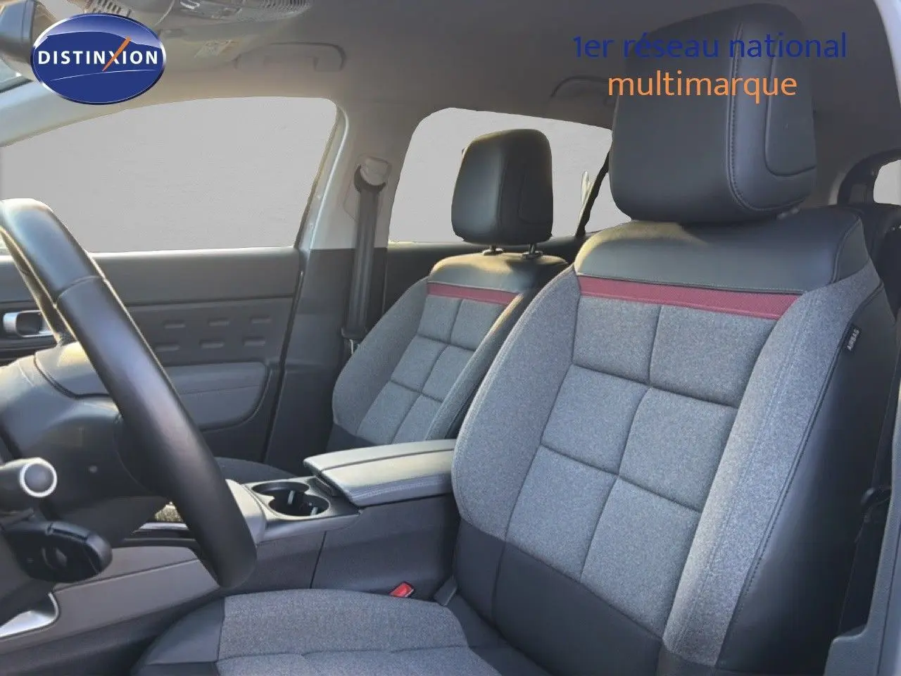 Vue intérieure côté conducteur du Citroën C5 Aircross 2021, sièges gris tissu et cuir avec bande rouge décorative.
