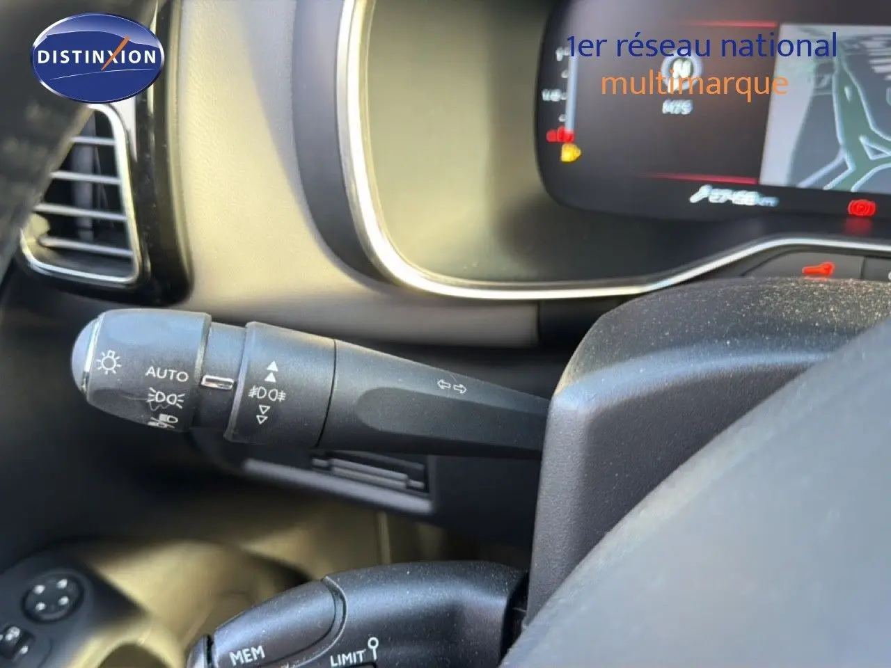 Gros plan sur la manette de clignotant et les commandes d’éclairage du tableau de bord d’un Citroën C5 Aircross gris Artense.