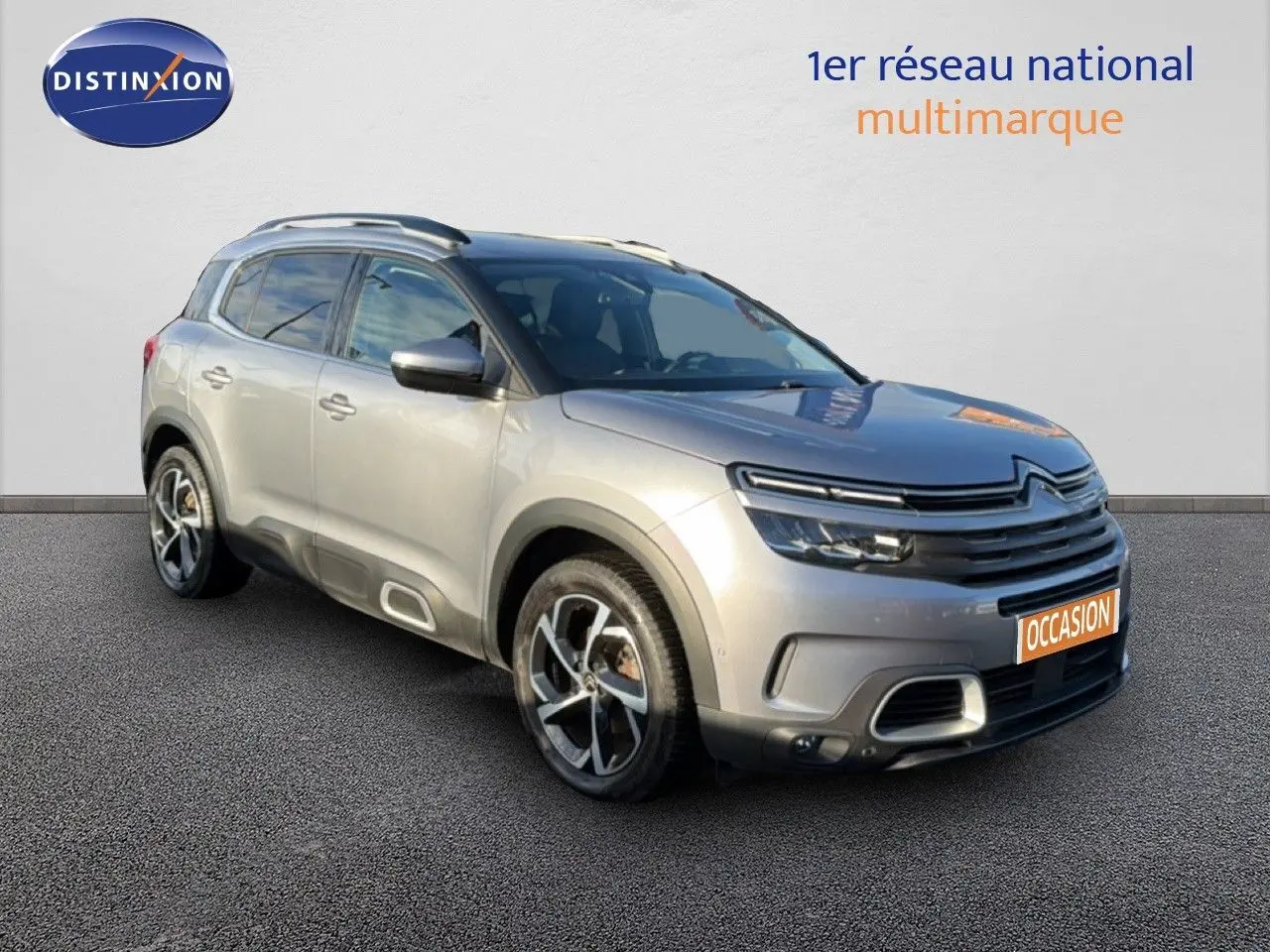 Vue 3/4 avant droit d'un Citroën C5 Aircross gris Artense métal avec jantes bi-ton et signature lumineuse LED.