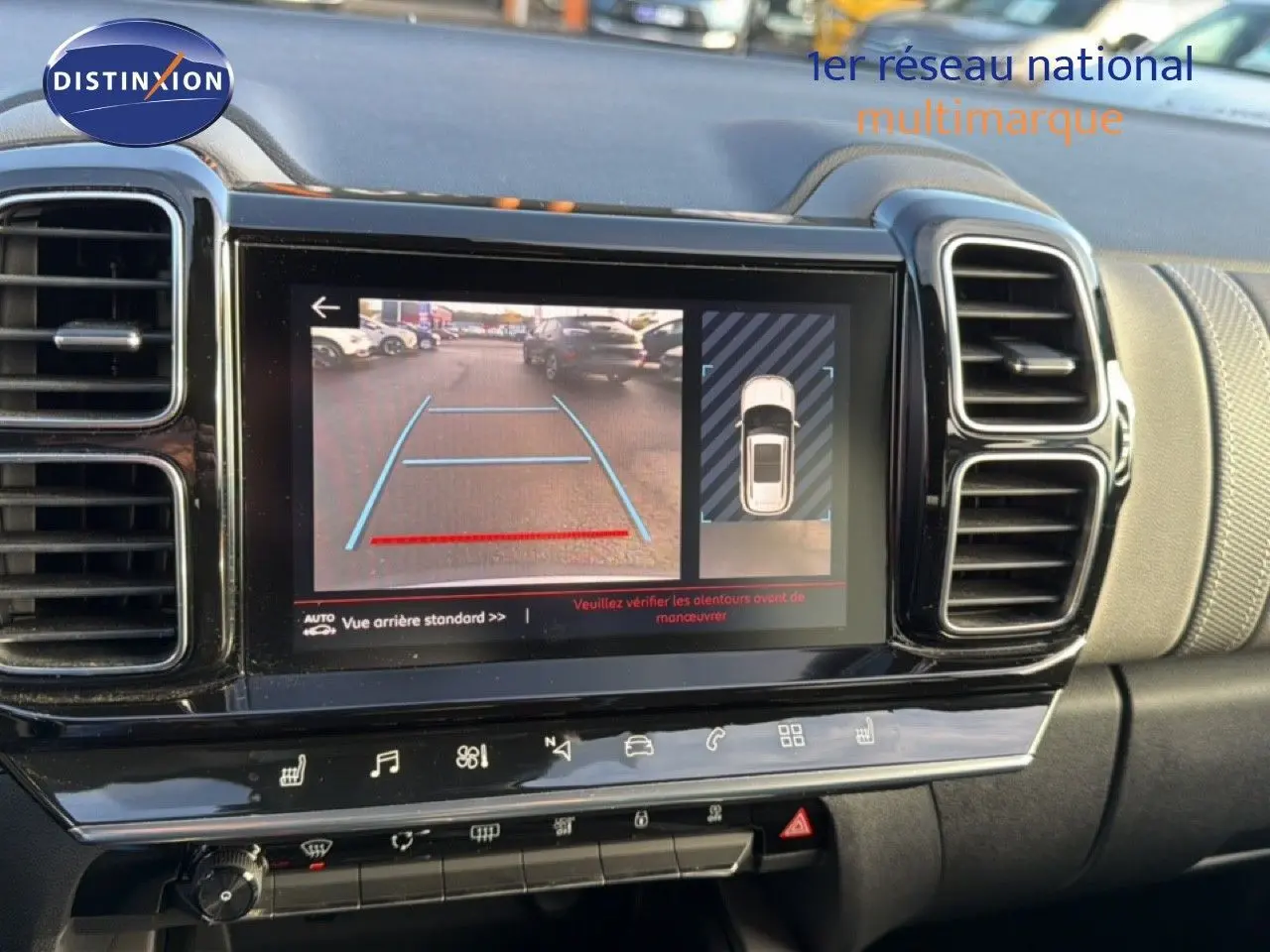 Vue rapprochée de l’écran central du tableau de bord du Citroën C5 Aircross gris, affichant la caméra de recul et l’aide au stationnement.