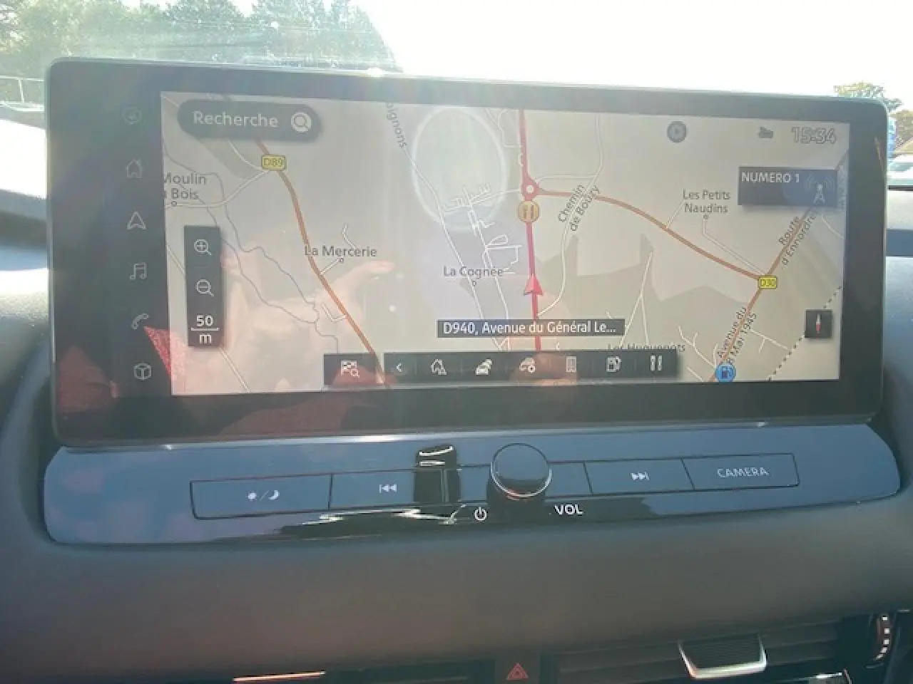 Écran tactile du système de navigation du Nissan Qashqai 2023 noir, vue intérieure centrée sur la console.