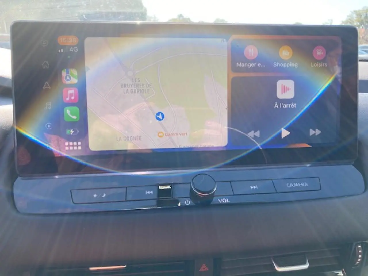 Écran tactile central du Nissan Qashqai 2023 noir, affichant navigation et commandes multimédia avec boutons physiques en dessous.