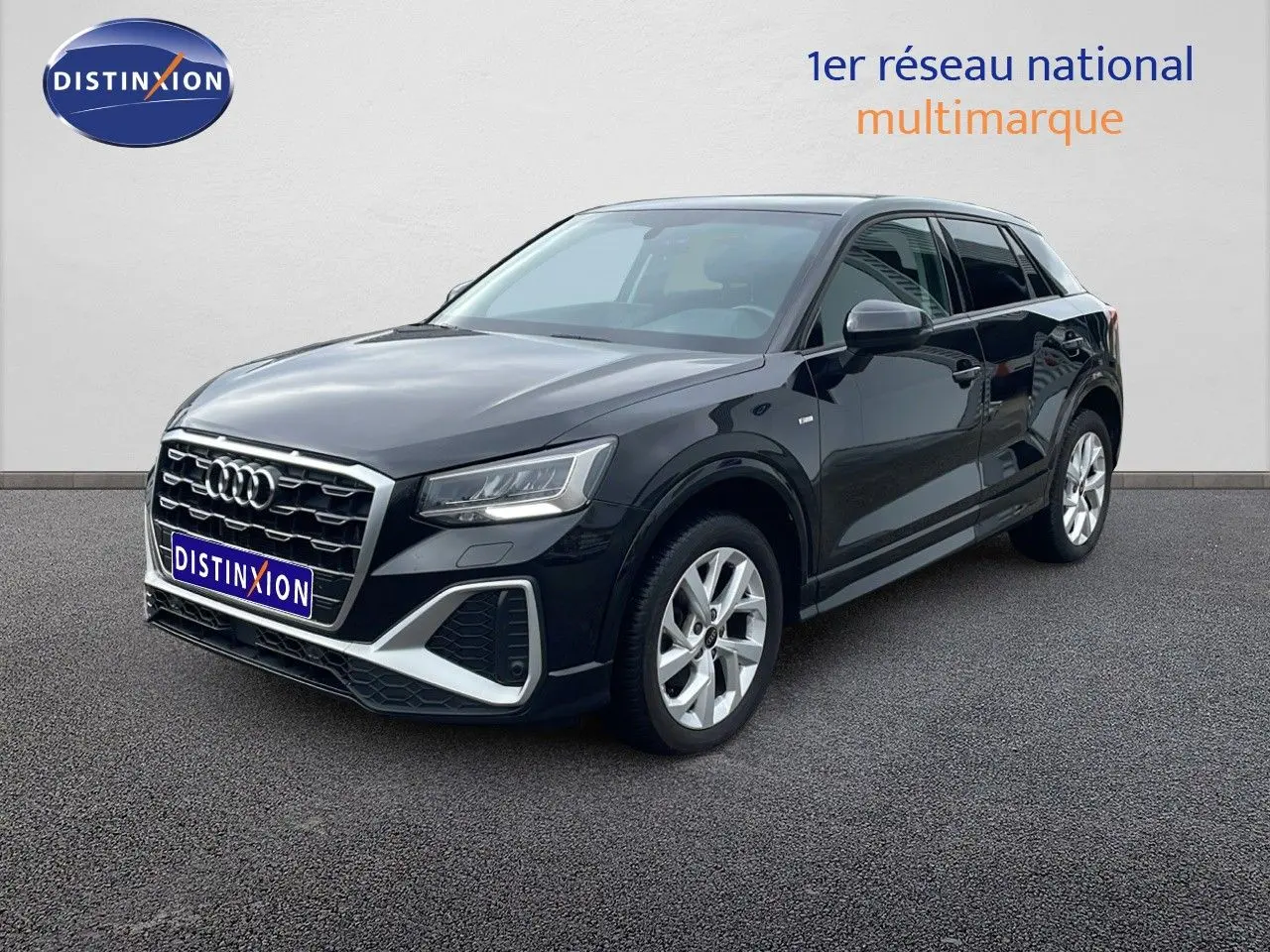 Audi Q2 noir mito metal en 3/4 avant droit, avec calandre hexagonale et jantes argentées visibles.