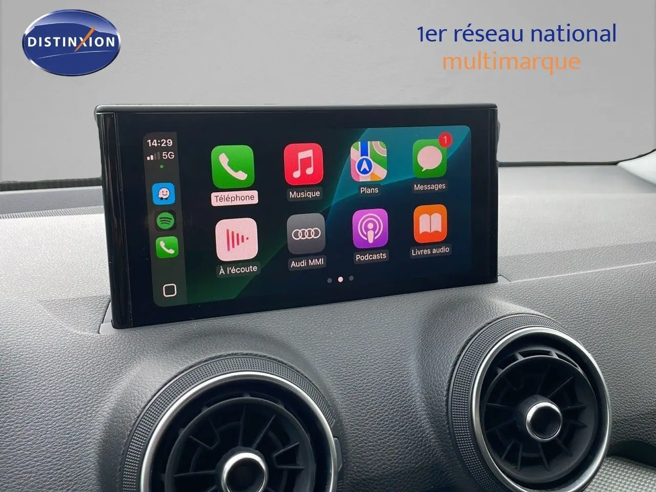 Écran tactile central affichant les applications Apple CarPlay dans l'habitacle noir d'un Audi Q2 2023.