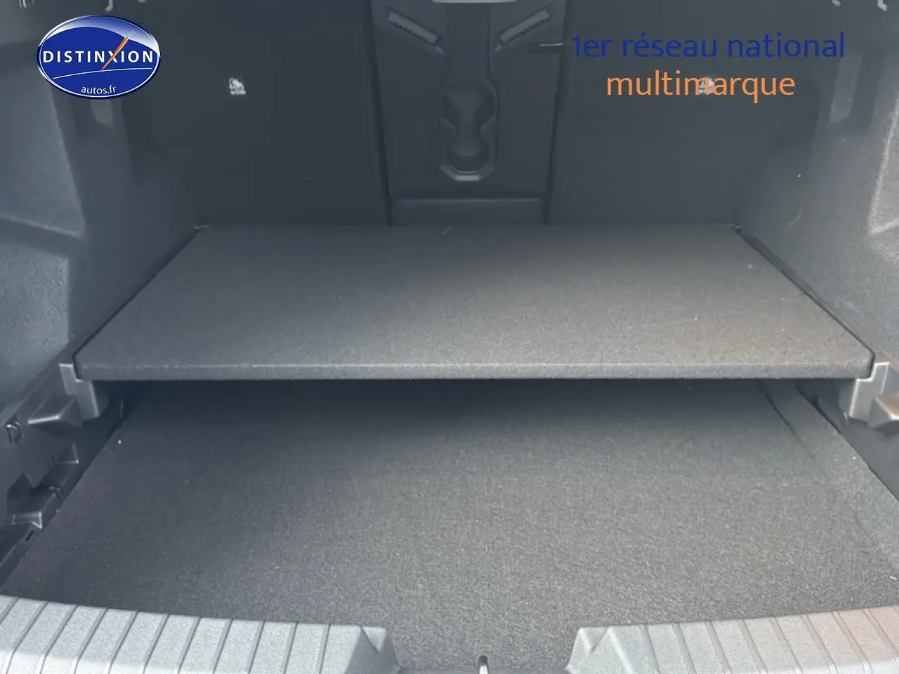 Coffre ouvert du Dacia Bigster 2025 vert cèdre, montrant le plancher modulable et l'espace de chargement.