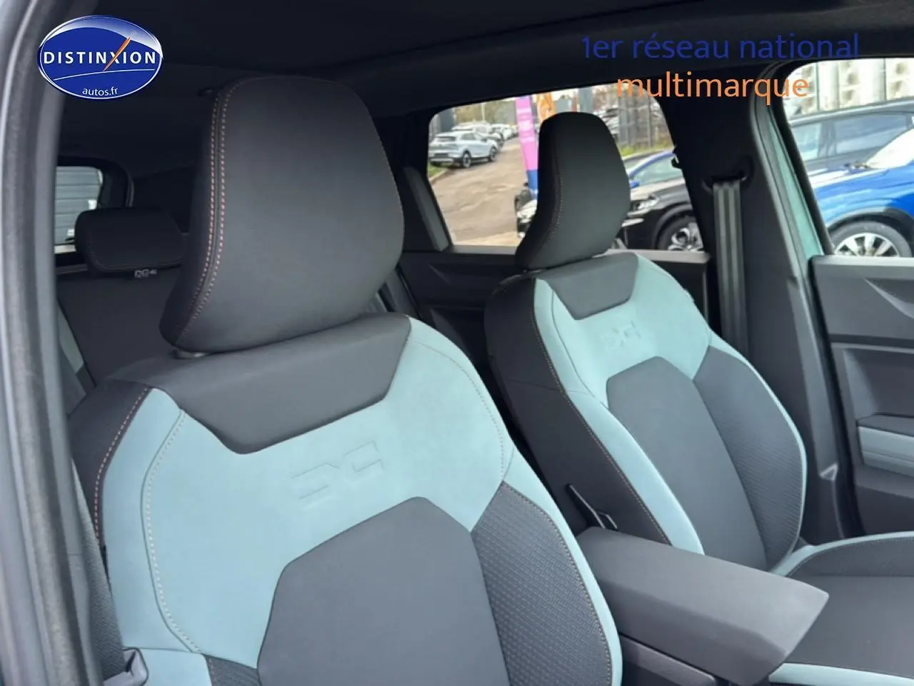 Gros plan sur les sièges avant bicolores gris et vert cèdre du Dacia Bigster 2025, avec accoudoir central visible.