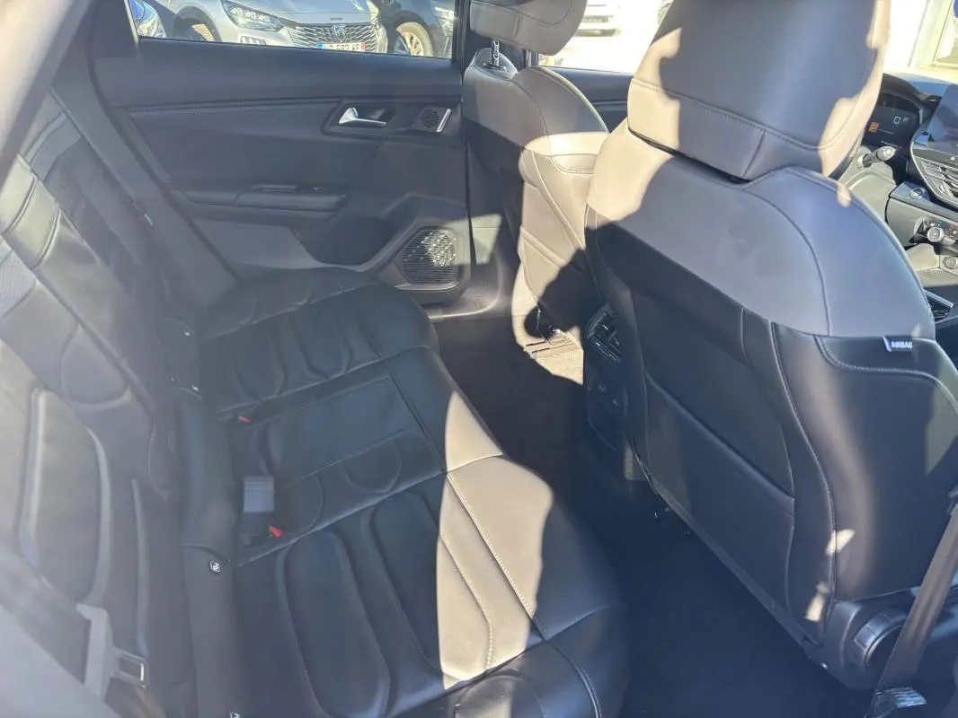 Vue intérieure côté gauche des sièges arrière en cuir noir du Citroën C5 X gris foncé, avec accoudoir central et aérateurs.