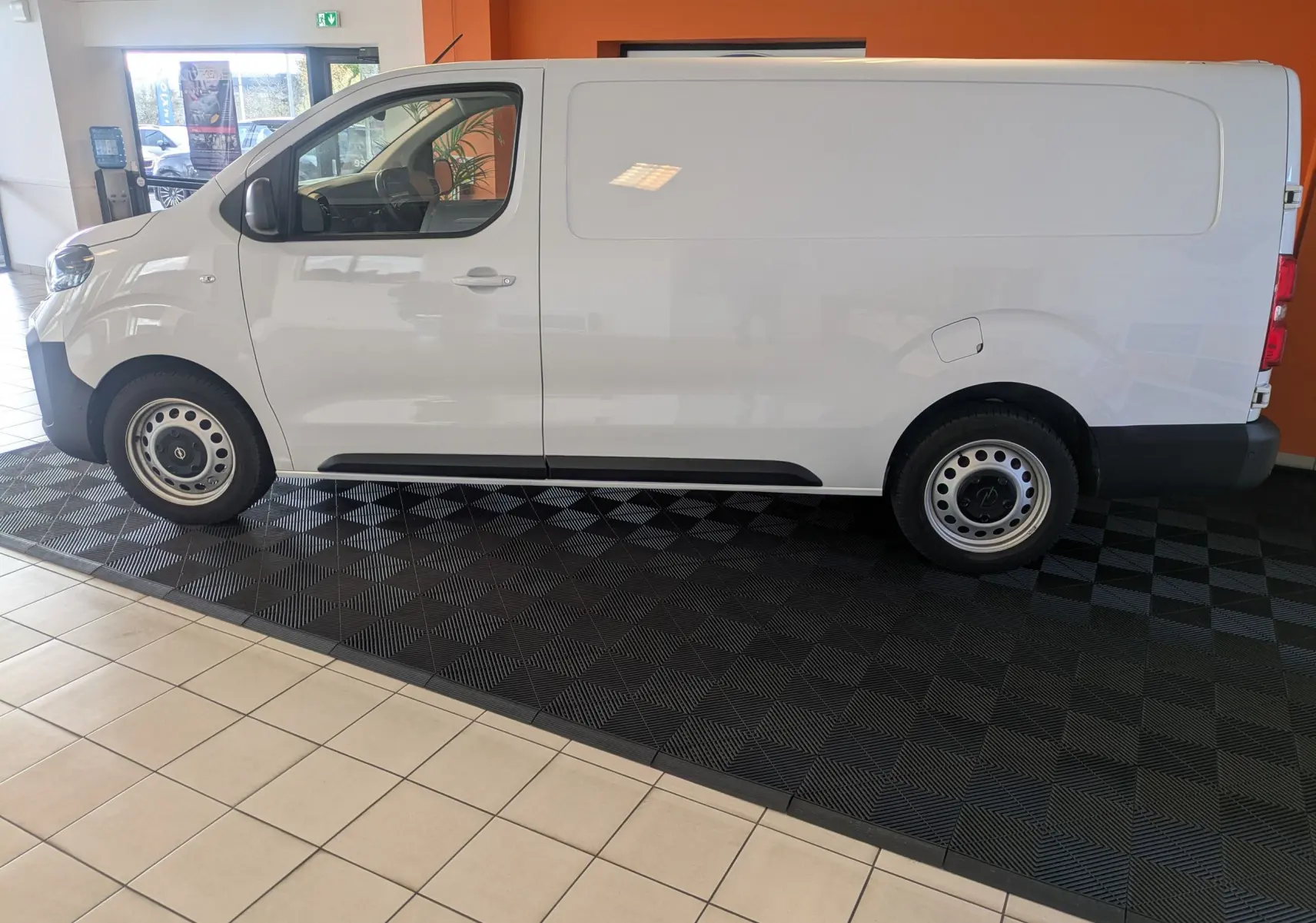 Vue de profil côté gauche d’un Opel Vivaro Fourgon XL blanc Icy avec jantes tôle 17 pouces en showroom.